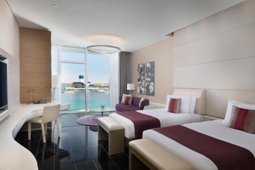 a hotel room with two beds and a view of the water at W Abu Dhabi - Yas Island in Abu Dhabi