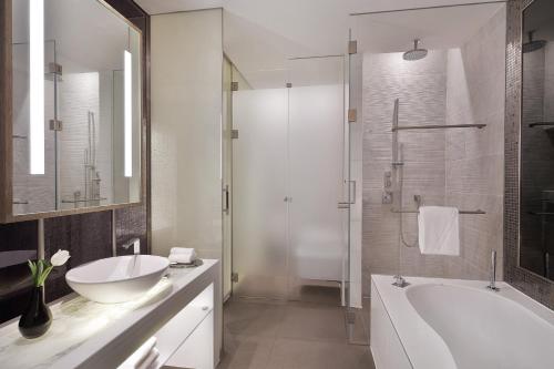 a bathroom with a tub and a sink and a shower at W Abu Dhabi - Yas Island in Abu Dhabi