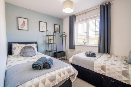 a bedroom with two beds with blue towels on them at Butterfly Gardens 2 bed apartment sleep upto 4 in Woodville
