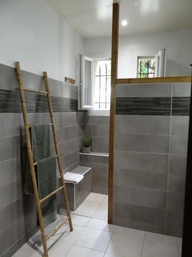 une salle de bain avec du carrelage gris et une douche dans l'établissement 37 au soleil, à Montréal