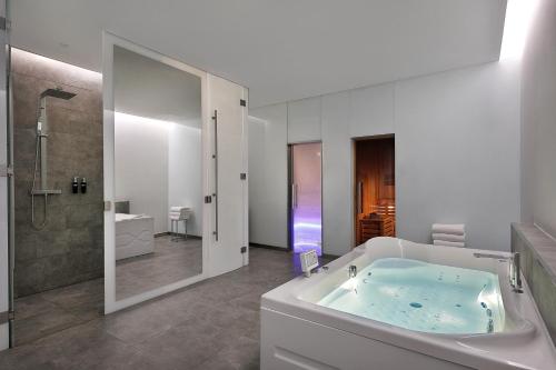 a bathroom with a tub and a shower and a sink at W Abu Dhabi - Yas Island in Abu Dhabi