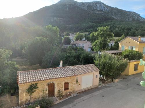 - une vue sur un village avec une montagne en arrière-plan dans l'établissement Pays du Verdon , étape, séjour fraîcheur dans maison de caractère, à La Bastide