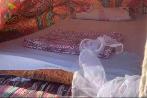 a bed with a dress on it with a bed sidx sidx at Blend in Nature Camp in Sharm El Sheikh