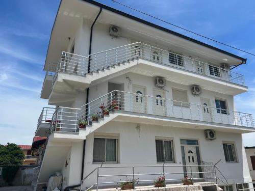 a white building with balconies and stairs on it at Kleida Beach Vacation Rentals in Spille