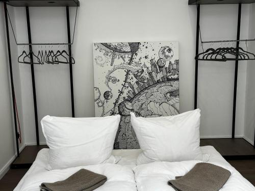 a bed with two pillows and a painting on the wall at Luxury City Apartment Downtown Vienna in Vienna