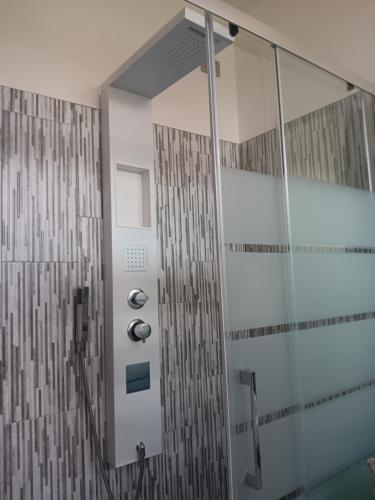 ducha con puerta de cristal y cabina de ducha en La Famiglia tripla, en Ca Bianca