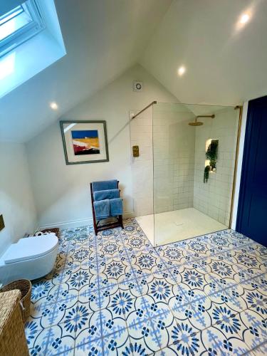 a bathroom with a shower and a blue chair at The Pool House in Henley on Thames