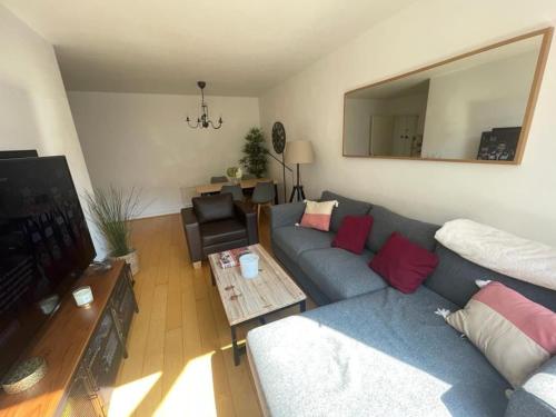 ein Wohnzimmer mit einem blauen Sofa und einem TV in der Unterkunft Refurbished central apartment in London