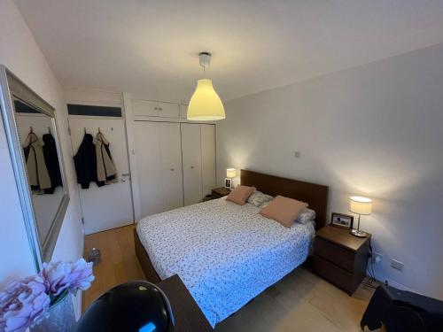 ein Schlafzimmer mit einem Bett, einem Tisch und einer Lampe in der Unterkunft Refurbished central apartment in London