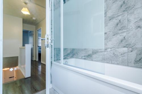 a bathroom with a bath tub and a mirror at Cozy Home Away From Home in Manchester. in Manchester