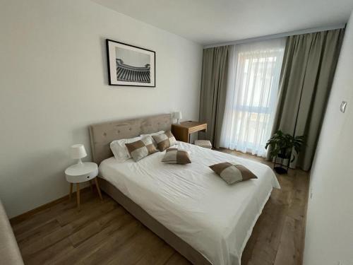 Un dormitorio con una cama grande con sábanas y almohadas blancas. en New Transilvania, en Cluj-Napoca