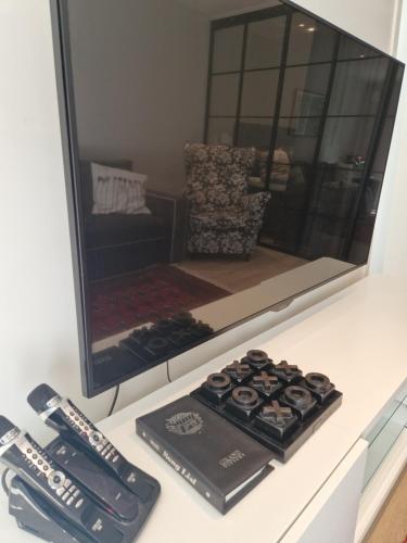 un mostrador con un espejo y dos controles remotos. en R apartment in Kungsängen, en Kungsängen