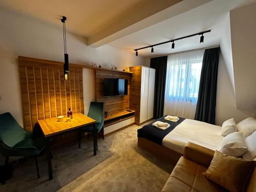 a hotel room with a bed and a table and a television at Dana Apartmani in Kopaonik