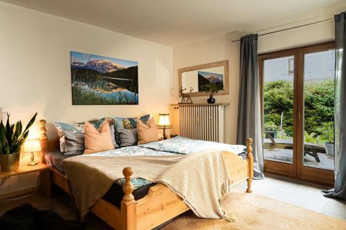 sypialnia z łóżkiem i przesuwnymi szklanymi drzwiami w obiekcie Engelsherz w mieście Mittenwald