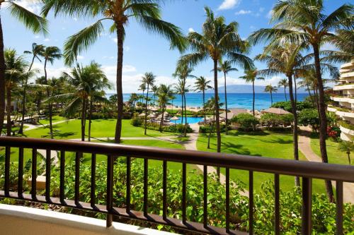 a view from the balcony of a resort with palm trees and the ocean at Sheraton Maui Resort & Spa in Lahaina