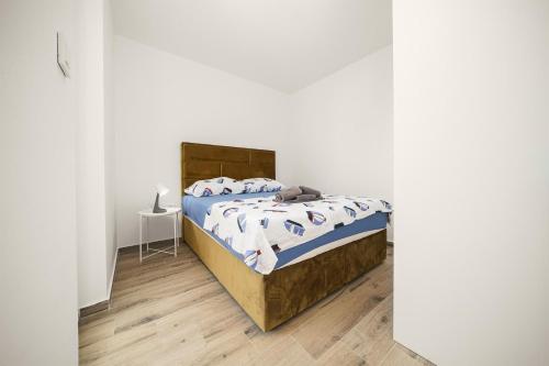 a bedroom with a bed with a wooden headboard at Apartments Picikato in Bilice