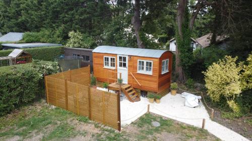 a tiny house sitting on top of a yard at Cobo Cottage in Chichester