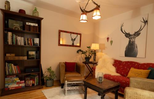 a living room with a red couch and a book shelf at Engelsherz in Mittenwald