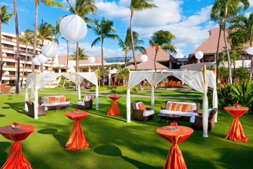 a resort yard with a gazebo and chairs and palm trees at Sheraton Maui Resort & Spa in Lahaina