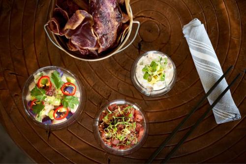 a wooden table topped with bowls of food and meat at Sheraton Maui Resort & Spa in Lahaina