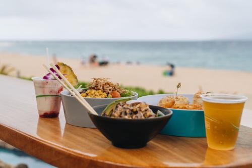 a table with three bowls of food and a drink at Sheraton Maui Resort & Spa in Lahaina