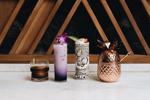a table with three vases and a drink at Sheraton Maui Resort & Spa in Lahaina