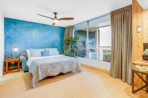 ein Schlafzimmer mit einem Bett und einer blauen Wand in der Unterkunft Mana Kai 803 in Wailea