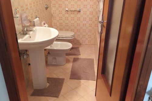 a bathroom with a white sink and a toilet at Dream House in Clusone
