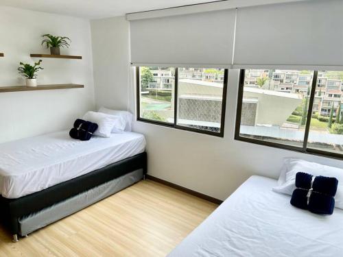 2 Betten in einem Zimmer mit Fenster in der Unterkunft Apartamento el poblado cerca a Provenza in Medellín