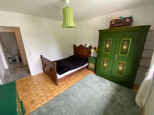 a bedroom with a green bed and a green cabinet at Natur Pur im Hochschwarzwald in Herrenschwand