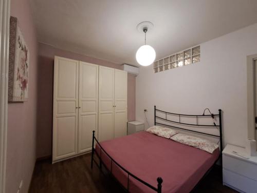 een slaapkamer met een bed met een roze deken bij Bilocale centro storico in Pesaro