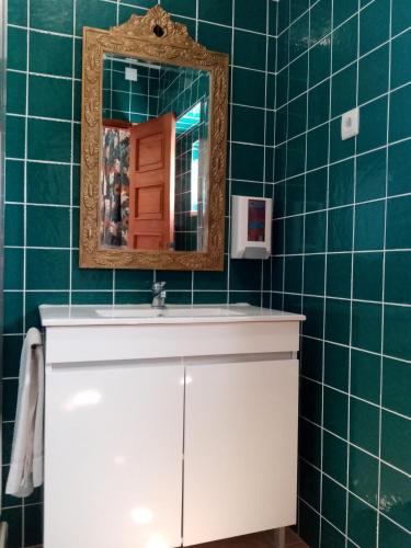 a bathroom with a white sink and a mirror at Alentejo Cante & Vinho in Ferreira do Alentejo
