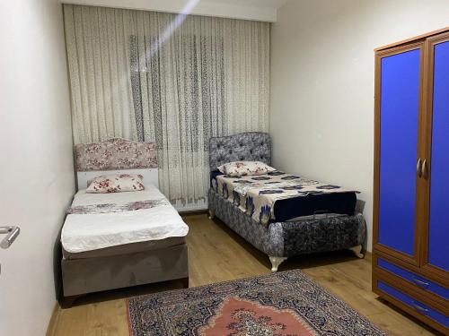 um pequeno quarto com 2 camas e uma cadeira em Apartment em Büyükçekmece