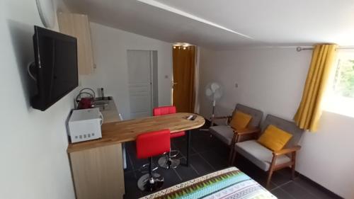 une pièce avec une table, des chaises et une télévision dans l'établissement Le bon coin jardin acces autonomie parking gratuit devant, à Castres