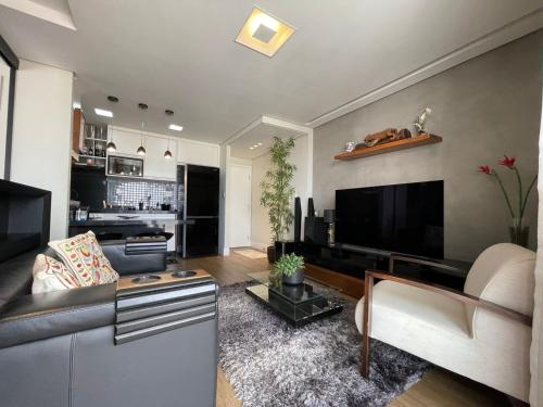 een woonkamer met een bank en een flatscreen-tv bij Studio Deluxe - Dot 173 in Campinas