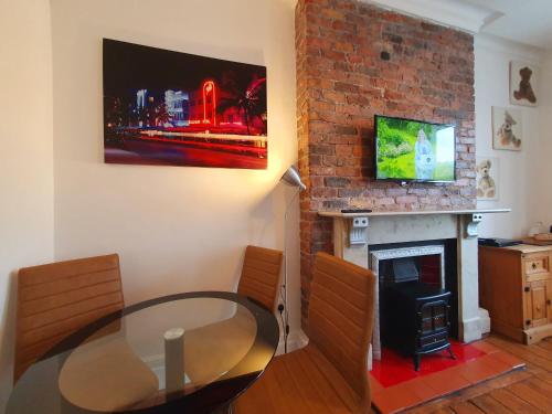 a dining room with a glass table and a fireplace at F3 2 BEDROOMED TOWN HOUSE - FREE Parking - Super 150 Mbps WiFi Near Gavin n Stacey Film House - 1 FREE DOG ALLOWED in Barry
