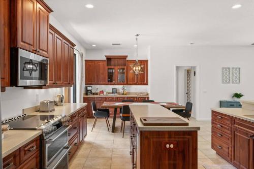 a large kitchen with wooden cabinets and a table at Cozy 3BR Gulf Coast house with heated pool in Englewood