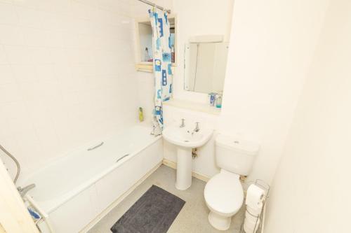 een badkamer met een toilet, een bad en een wastafel bij Jah lodge in Croydon