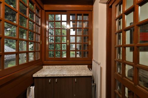 eine Küche mit zwei Fenstern und einer Theke in einem Zimmer in der Unterkunft Apartamento de 1 quarto in Gramado