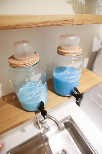 deux bocaux en verre posés sur une étagère au-dessus d'un évier dans l'établissement Elégant appartement parisien, à Paris