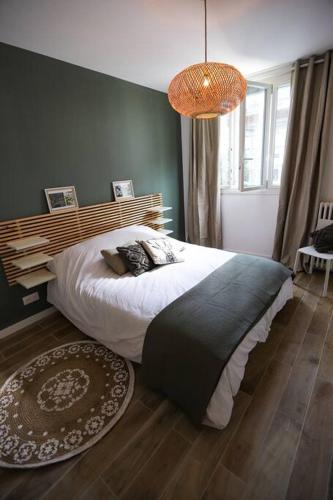 une chambre avec un grand lit et un lustre dans l'établissement Elégant appartement parisien, à Paris