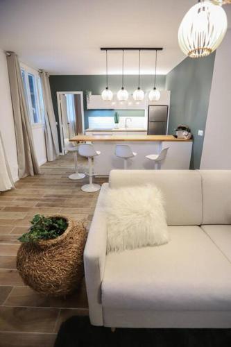 un salon avec un canapé blanc et une table dans l'établissement Elégant appartement parisien, à Paris