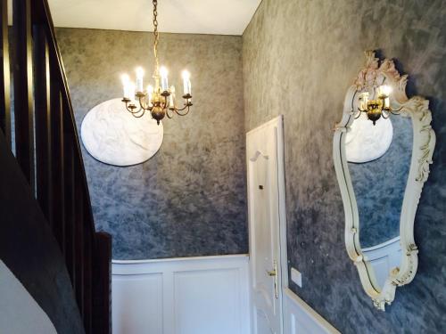 a hallway with a mirror and a chandelier at Parkhotel Fischer in Wernigerode