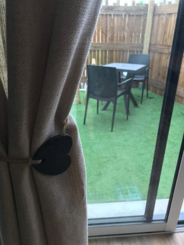 d'une fenêtre donnant sur une terrasse avec une table. dans l'établissement Le Cocon du bourg d’Agon, à Agon-Coutainville