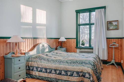 Piece of Hjo Vandrarhem في هيو: غرفة نوم بسرير ومصباحين ونافذة