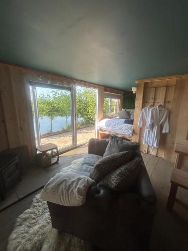 a living room with a couch and a bed at Secluded Lakeside Off Grid Cabin with Outdoor Bath in Rhosneigr