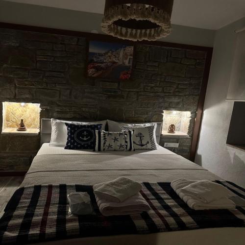 1 dormitorio con 1 cama grande y pared de piedra en Çeşmeli Konak, en Canakkale