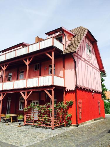 a red building with a balcony on the side of it at Parkhotel Fischer in Wernigerode