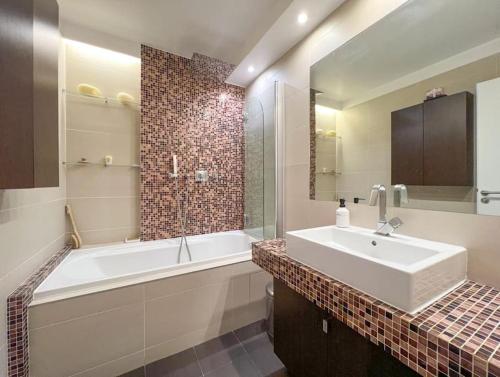 a bathroom with a white tub and a sink and a bath tub at Full apt - Top floor - Eiffel Tower Panoramic View in Issy-les-Moulineaux