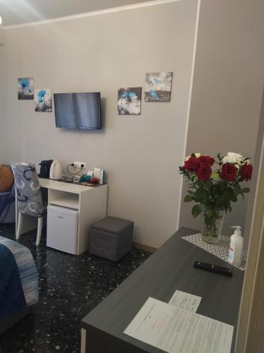 a room with a table with a vase of roses at La Casa di Sonia in Savona